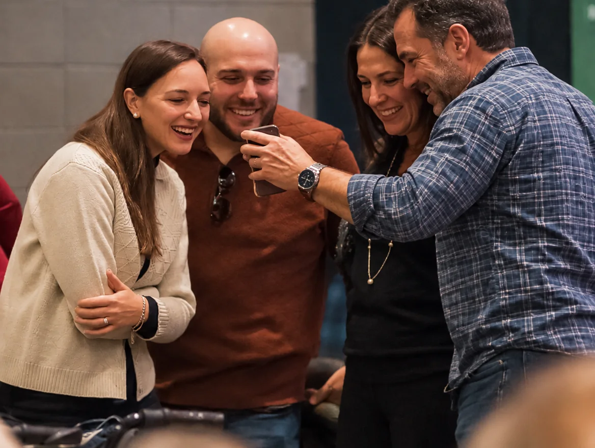 Two couples at Hope Community Church looking at a phone together after a service